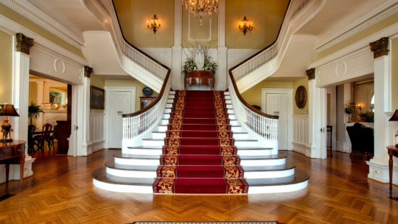 Owning The Best House In The Neighborhood - Foyer With Grand Staircase With Carpeted Runner